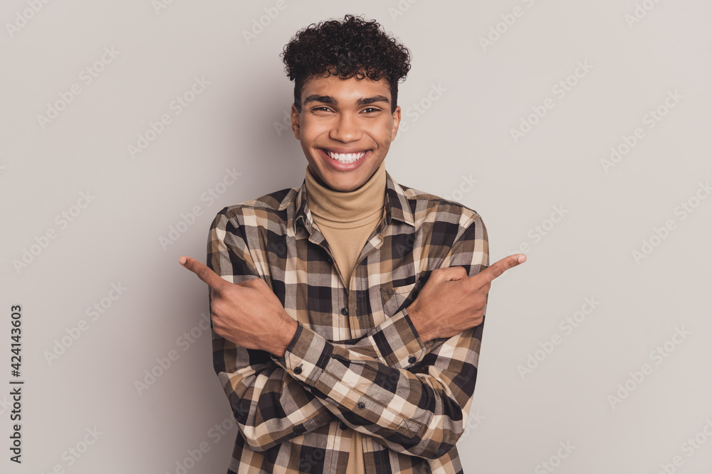 Photo of positive guy direct fingers empty space wear plaid shirt turtleneck isolated grey color background Photo of positive guy direct fingers empty space wear plaid shirt turtleneck isolated grey color background