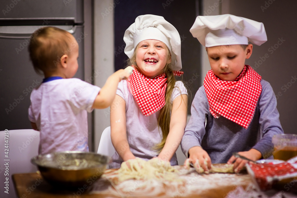 happy family fun kids baking cookies in the kitchen in chef caps selective focus happy family fun kids baking cookies in the kitchen in chef caps selective focus
