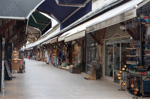 A long curving row at the Turkish tourist market in the heart of Istanbul. The counters are filled with various goods: hookahs, leather items, fabrics, clothes, souvenirs and much more.