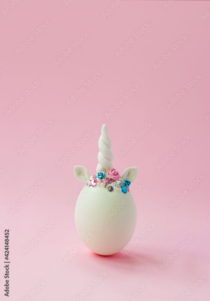 Single white egg, with unicorn decoration; Creative minimal Easter background with copy space Single white egg, with unicorn decoration; Creative minimal Easter background with copy space