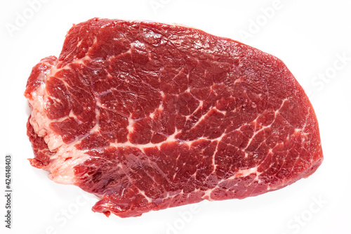 piece of raw meat on white plate, grain-fed marbled beef, top view, best meat for steaks