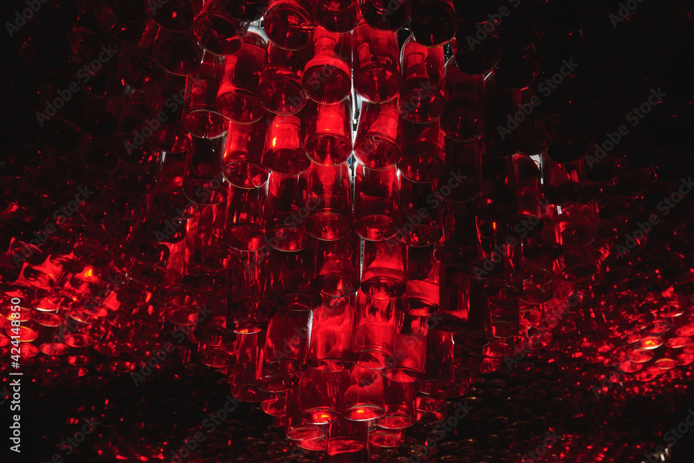 Ceiling of bar made from many bottles with red liquid. Atmosphere bar with low light. Alcohol drinks concept photo. Horizontal photo. Ceiling of bar made from many bottles with red liquid. Atmosphere bar with low light. Alcohol drinks concept photo. Horizontal photo.