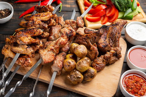 Assorted delicious kebabs on dark wooden background
