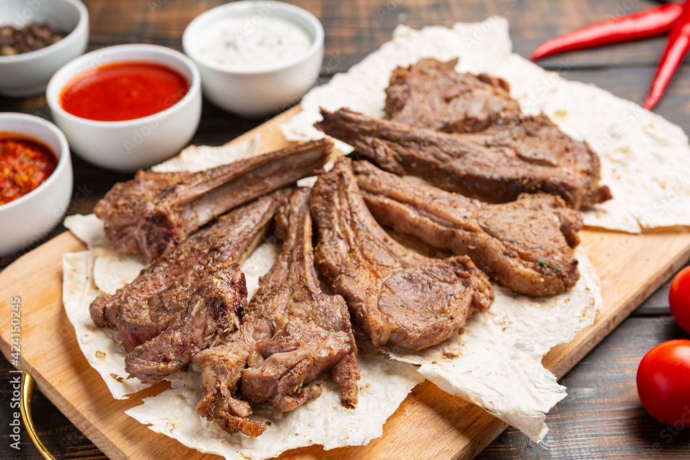 Roasted lamb ribs with sauce on wooden background, Roasted lamb ribs with sauce on wooden background,