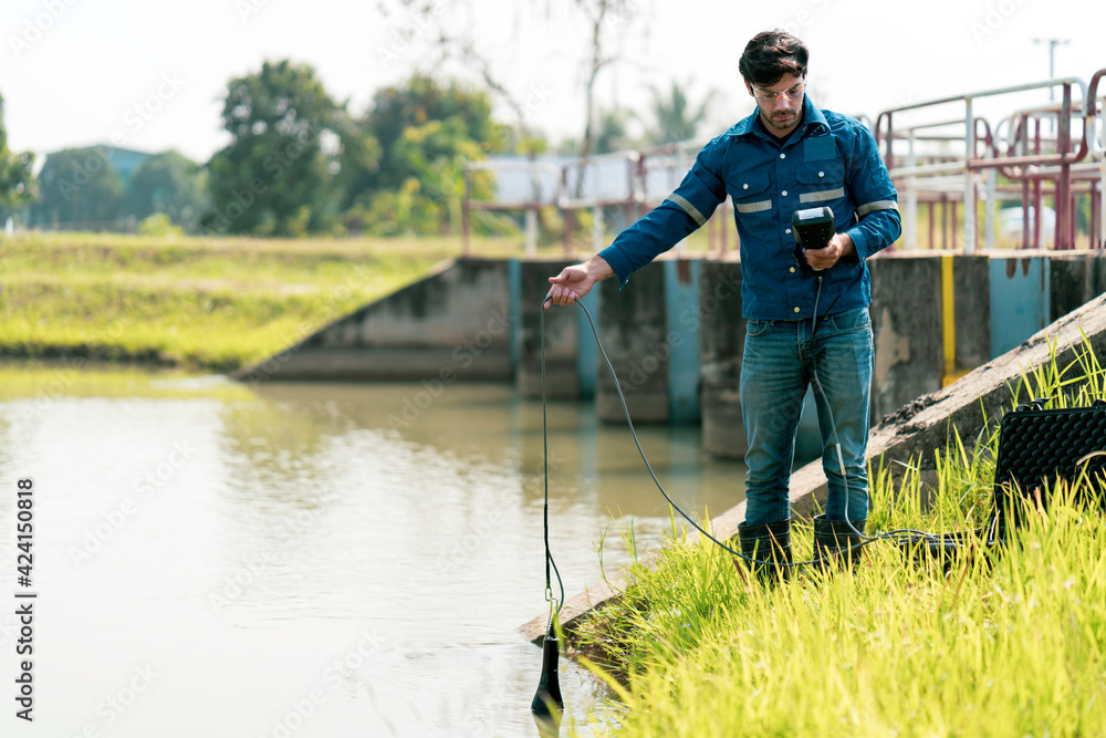 A technician use the Professional Water Testing equipment to measure the water quality at the public canal ,Portable multi parameter water quality measurement ,water quality monitoring concept A technician use the Professional Water Testing equipment to measure the water quality at the public canal ,Portable multi parameter water quality measurement ,water quality monitoring concept