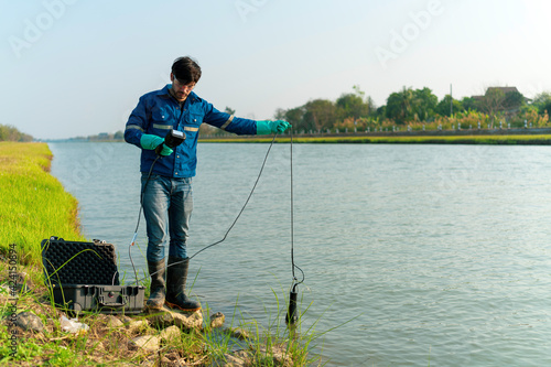 A technician use the Professional Water Testing equipment to measure the water quality at the public canal ,Portable multi parameter water quality measurement ,water quality monitoring concept