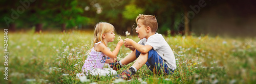 happy children play outdoor with the dandelions