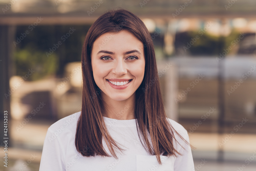 Photo portrait of female student wearing white casual t-shirt smiling standing on the street Photo portrait of female student wearing white casual t-shirt smiling standing on the street