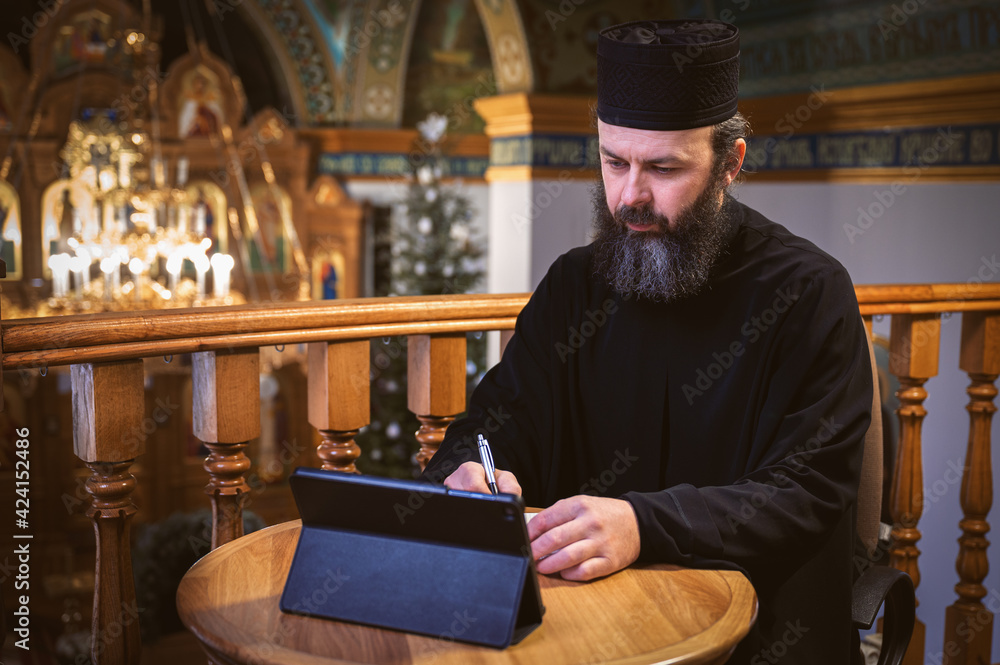 . An Orthodox priest is recording a video for his blog. Preaching during a pandemic.