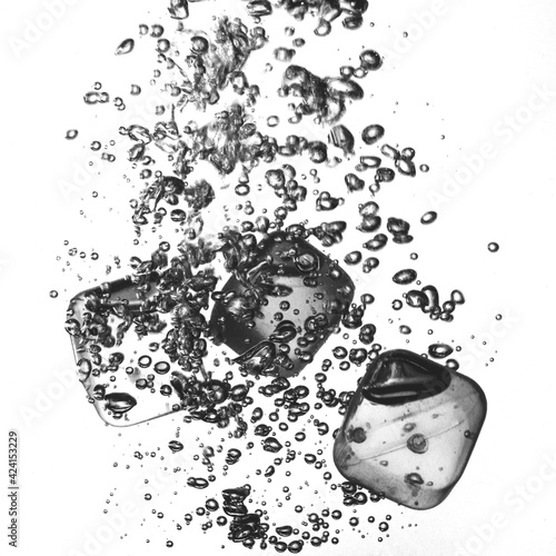 Trois glaçons tombent dans un verre d'eau fraiche photo