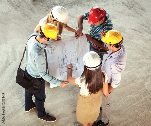 Group of architects and engineers discuss about construction blueprint.High angle view. 