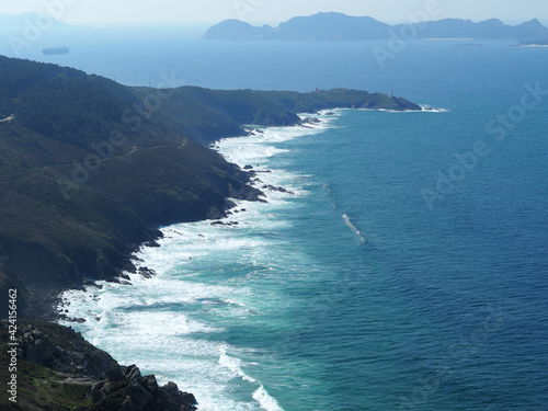 The rocky coast with the waves, the islands and the ocean in the background. © macizogalaico