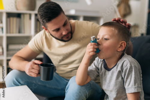 Photography boy using asthma pump at home