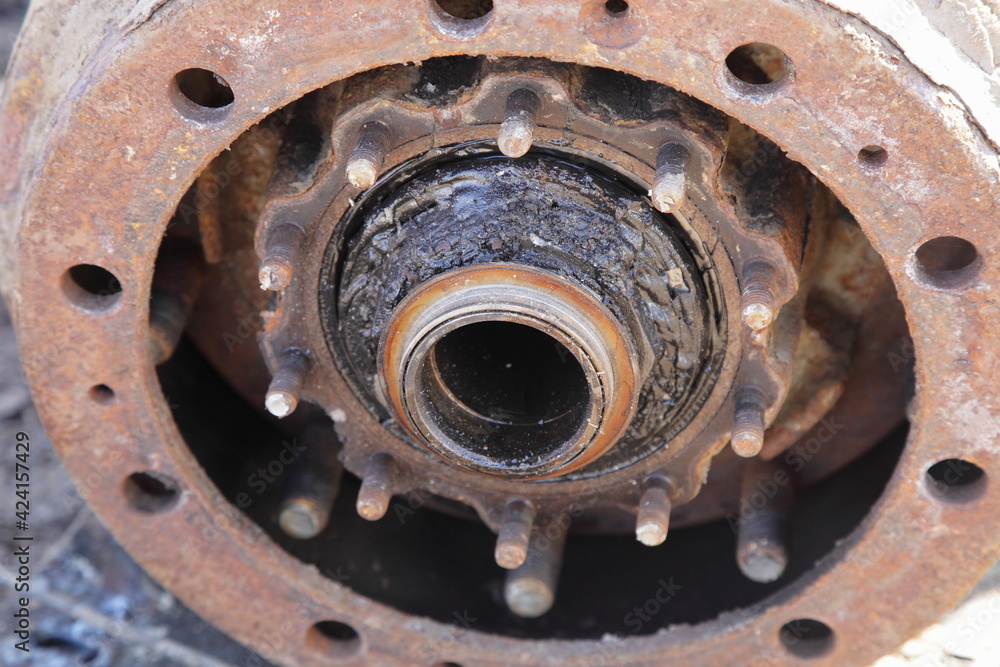 Dirty heavy truck drum brakes repair, disassembled hub bearing and brake drum with wheel pegs closeup
