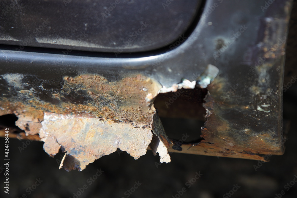 Throughcorrosion of the car door sill closeup, rust hole in vehicle