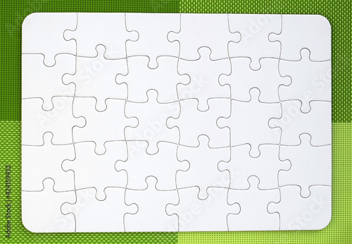 White jigsaw puzzle on green background of four shades photo