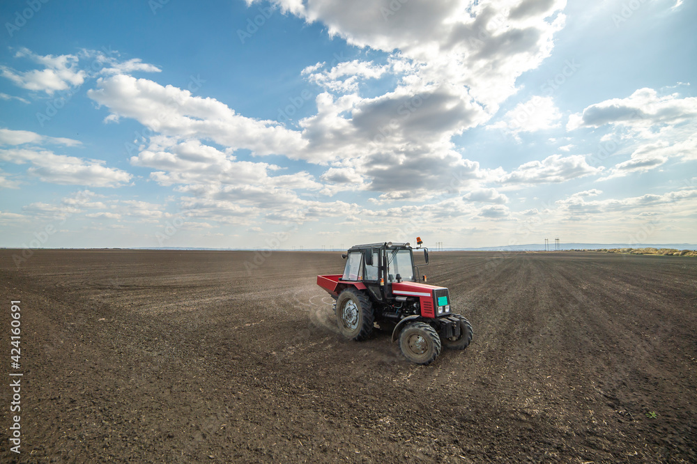 Obraz premium Tractor spreading artificial fertilizers