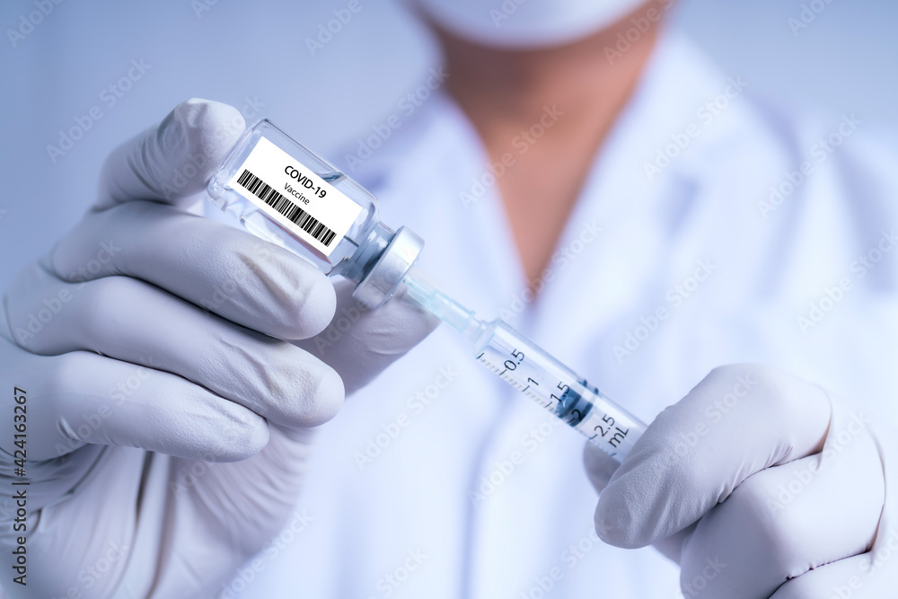 Doctor filling syringe with medication.Concept fight against virus covid-19 corona virus, doctor or scientist in laboratory holding a syringe with liquid vaccines Doctor filling syringe with medication.Concept fight against virus covid-19 corona virus, doctor or scientist in laboratory holding a syringe with liquid vaccines