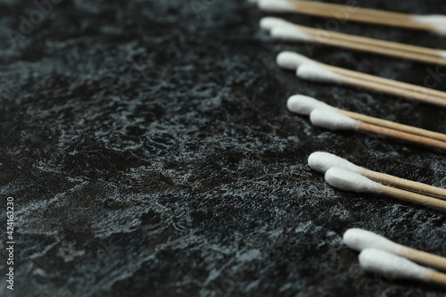 Cotton swabs on black smoky background, space for text