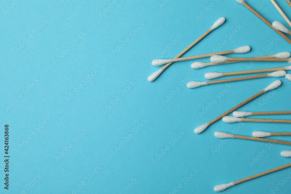 Cotton swabs on blue background, space for text Cotton swabs on blue background, space for text