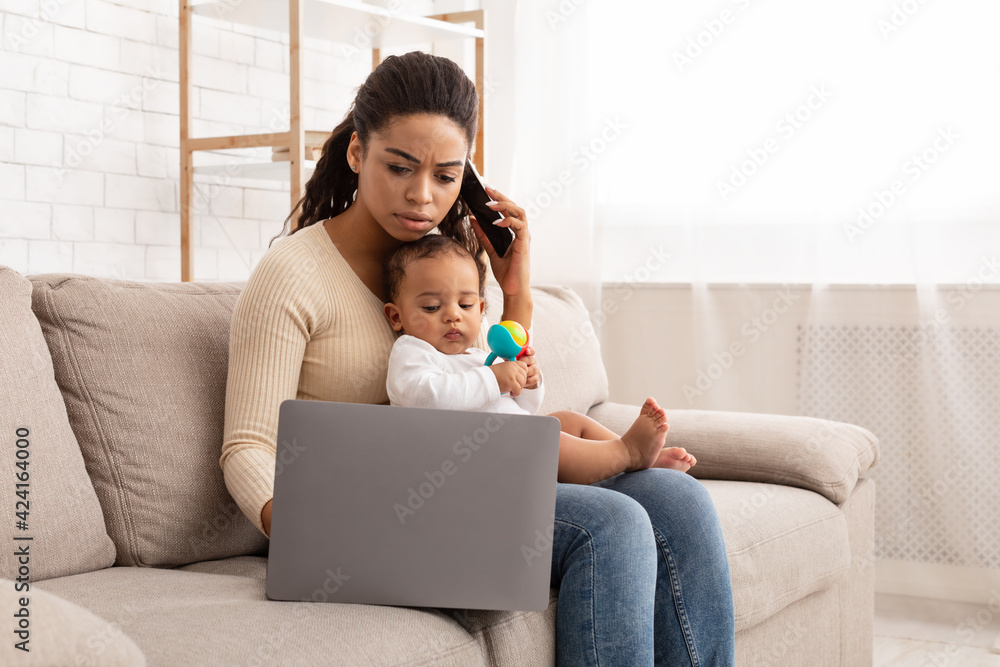 African Mom Working On Laptop Holding Baby Sitting At Home African Mom Working On Laptop Holding Baby Sitting At Home
