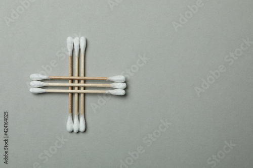 Wooden cotton swabs on light gray background  space for text