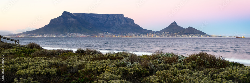 Table Mountain silhouetted against the morning sky as viewed from Sunset Beach in Milnerton, Cape Town South Africa.