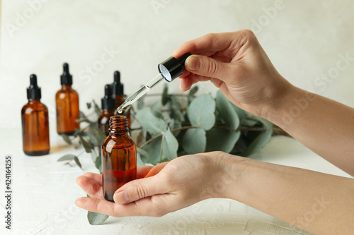 Concept of natural cosmetics with female hand dripping eucalyptus oil