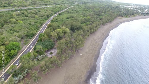 Vue Aérienne par drone de la plage de l'étang-Salé à l'île tropicale de La Réunion entre la mer et la route sur laquelle passe le trafic et les transports derrière la plage vide