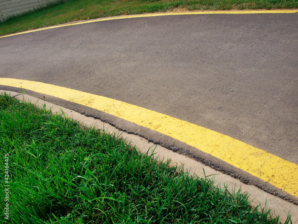 Obraz premium Cycling or jogging track and green grass in the park