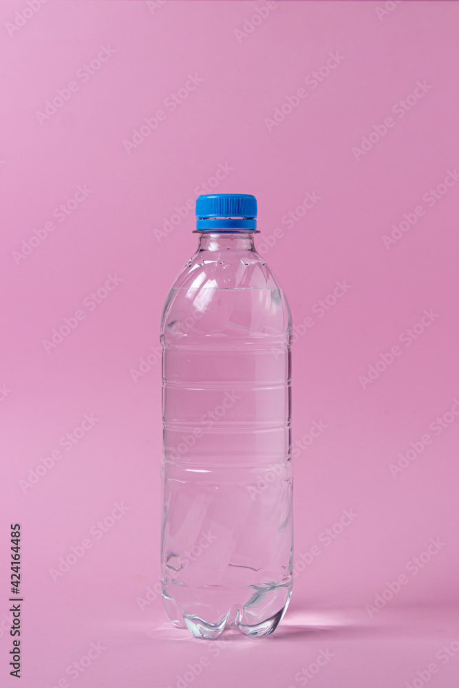 Water bottle on a pink background. Plastic bottle with water. Clean drinking water. Water bottle on a pink background. Plastic bottle with water. Clean drinking water.