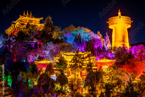 Guishan Dafo Big Buddha temple with the giant Tibetan Buddhist prayer wheel colourfully illuminated at night long exposure shot Shangri-La Yunnan China