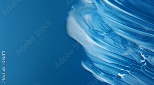 Lotion for skincare smear on cyan blue gradation colorful background with copy or negative space
