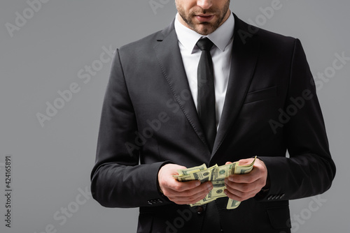 Partial view of businessman counting money isolated on grey