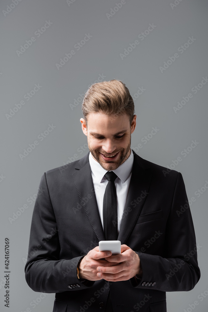 smiling manager messaging on smartphone isolated on grey smiling manager messaging on smartphone isolated on grey