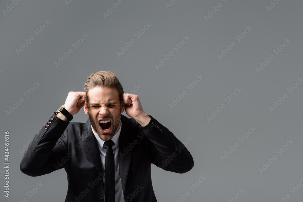 angry businessman showing clenched fists and shouting isolated on grey angry businessman showing clenched fists and shouting isolated on grey