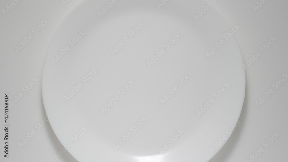 TOP VIEW: Big Empty white dish on a white table TOP VIEW: Big Empty white dish on a white table
