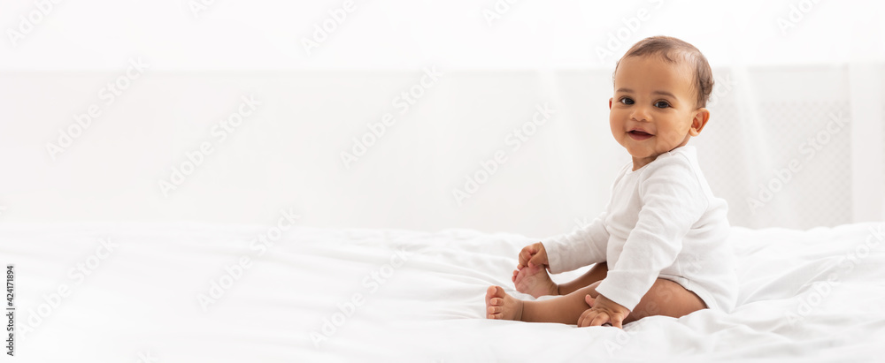 Happy Black Little Baby Girl Sitting In Bedroom At Home - obrazy, fototapety, plakaty 