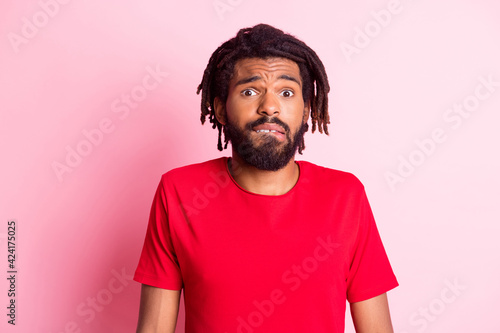 Photo of young afro guy unhappy bite lips teeth confused doubt questioned no answer isolated over pink color background
