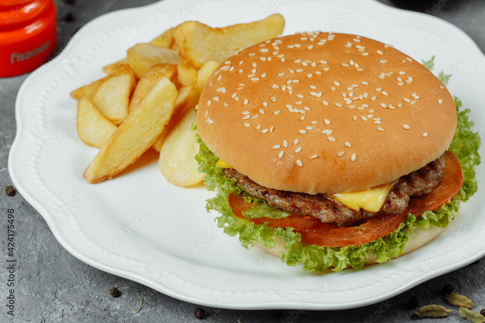 hamburger with fries and salad on the plate