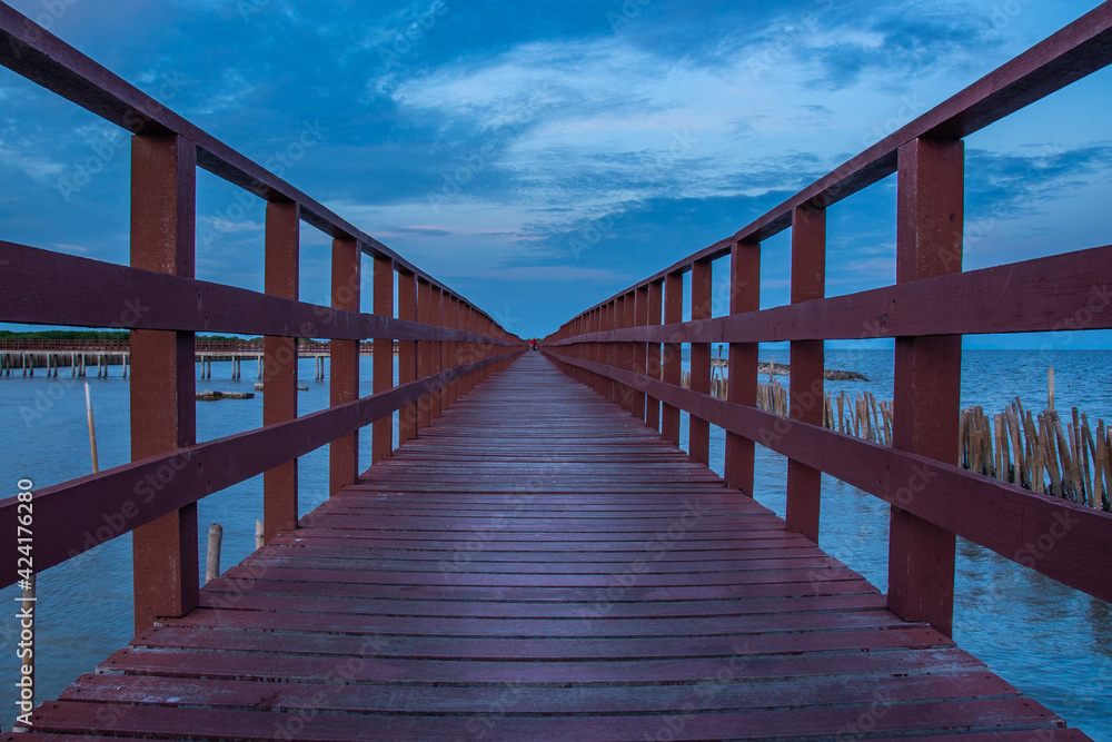 Beautiful of The walkway red wooden bridge in evening at Bang Khun Thian sea view, Bang Khun Thian, Bangkok, Thailand. Selective focus. Beautiful of The walkway red wooden bridge in evening at Bang Khun Thian sea view, Bang Khun Thian, Bangkok, Thailand. Selective focus.