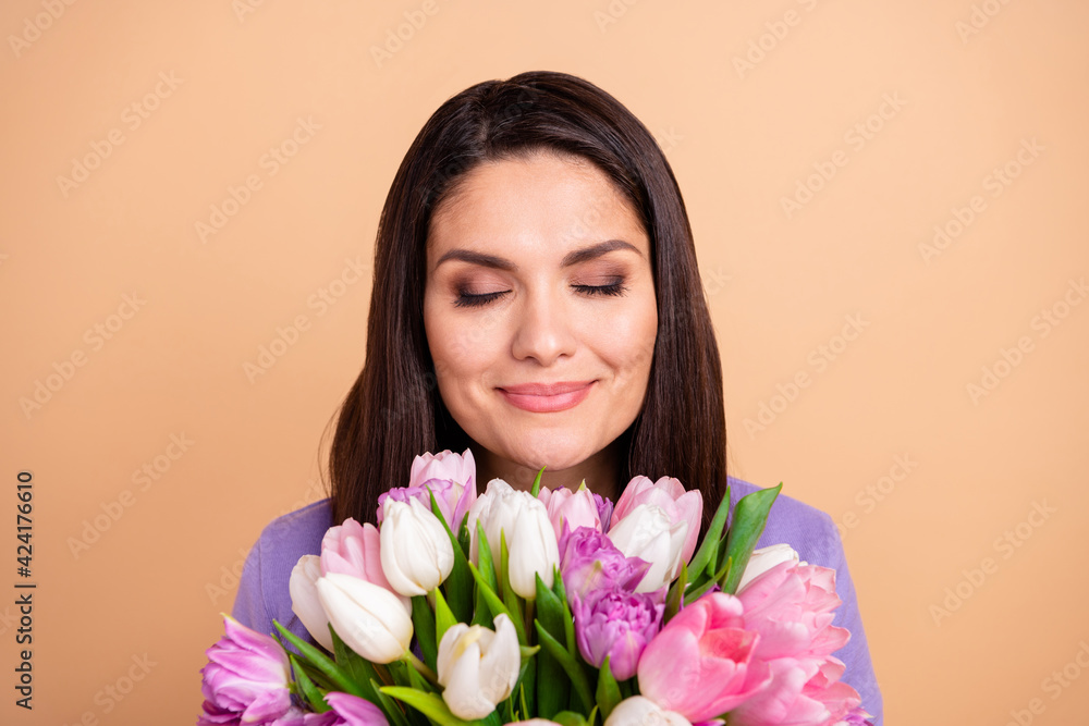 Photo of attractive woman happy positive enjoy smell aroma flower bouquet present isolated over beige color background