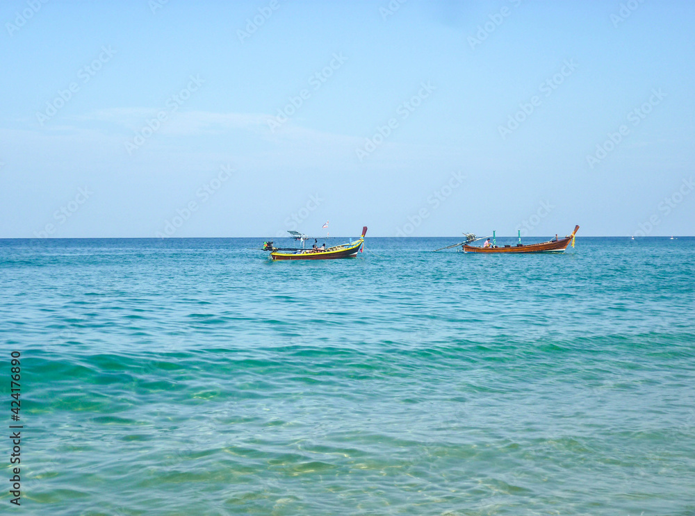 Two old wooden boats await tourists in the Andaman Sea. Two old wooden boats await tourists in the Andaman Sea.