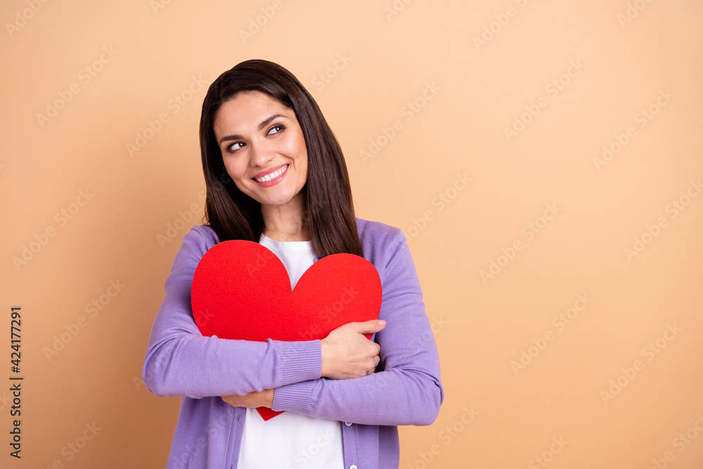 Photo of attractive woman happy positive smile dream hug red paper heart love romantic isolated over beige color background Photo of attractive woman happy positive smile dream hug red paper heart love romantic isolated over beige color background
