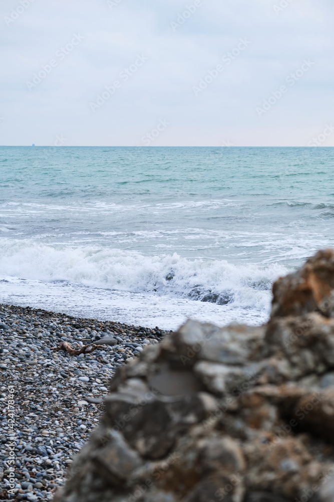 Peace and tranquility of nature. Large yellow granite stone in foreground and blue undulating sea in background. Landscape of the Black Sea coast.