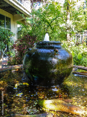 A fountain from a large old jug is installed in a park in Thailand.