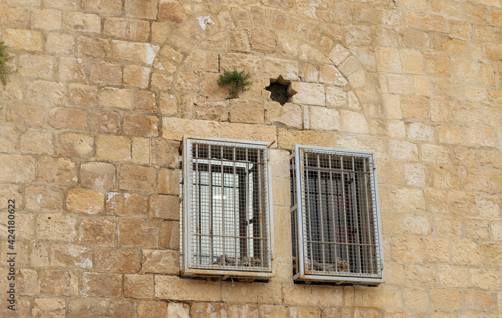 Windows with metal bars on the facade of an old building in the old city of Jerusalem, Israel Windows with metal bars on the facade of an old building in the old city of Jerusalem, Israel