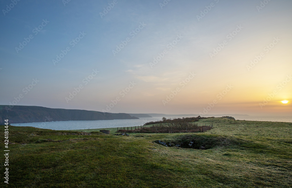 The cliffs of the Pembrokeshire coast in Wales at sunrise with dew on the ground