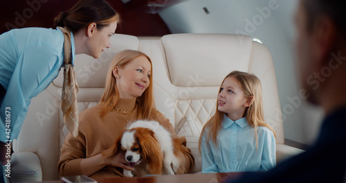 Φωτογραφία Flight attendant taking order from family in first class airplane interior
