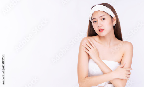 Charming young woman wear headband touching body with clean fresh body. Teenager before bathing while close her eyes over isolated white background. Beauty cosmetics and healthy skin concept.